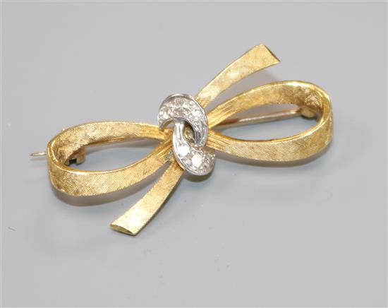 An 18ct gold and diamond set ribbon bow brooch, 33mm.
